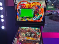 A Hot Wheels pinball machine stands indoors, with its lit display and playfield visible. - Photo by Solar_Rider (25 Jul 2026)