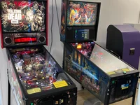 Two pinball machines, The Walking Dead and Black Knight: Sword of Rage, stand side-by-side in a room.