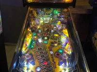 Un flipper lumineux nommé The Party Zone se trouve dans une pièce faiblement éclairée. - Photo par PillowPill (15 Aoû 2026)