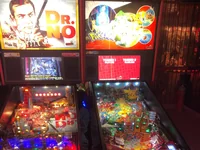 Two pinball machines, featuring Dr. No and Pokémon themes, stand side by side. - Photo by glenn pellis (20 Jul 2026)