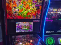 A Teenage Mutant Ninja Turtles pinball machine is shown in a lit arcade. - Photo by Solar_Rider (25 Jul 2026)